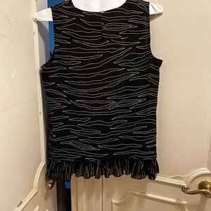 DKNY sleeveless black/white top ruffles on the bottom. Button closure.